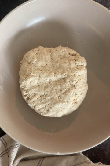 Soft tofu roti dough resting in a bowl.