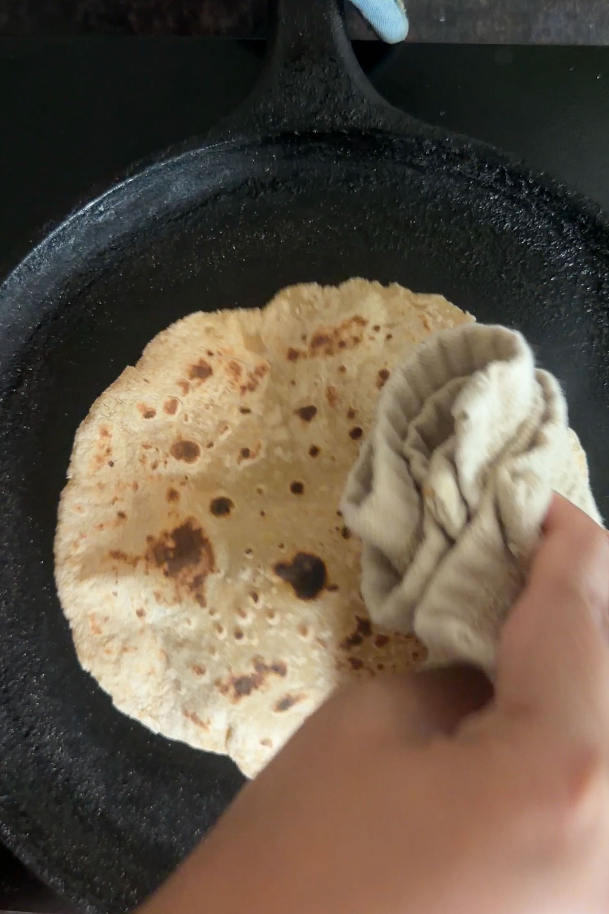 Tofu roti puffing while cooking on a hot tawa.